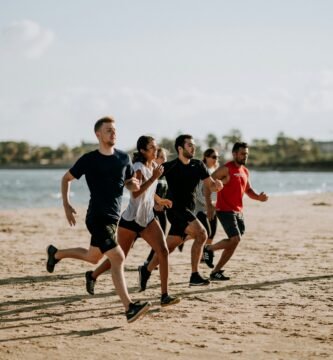 men and women running on sea shore